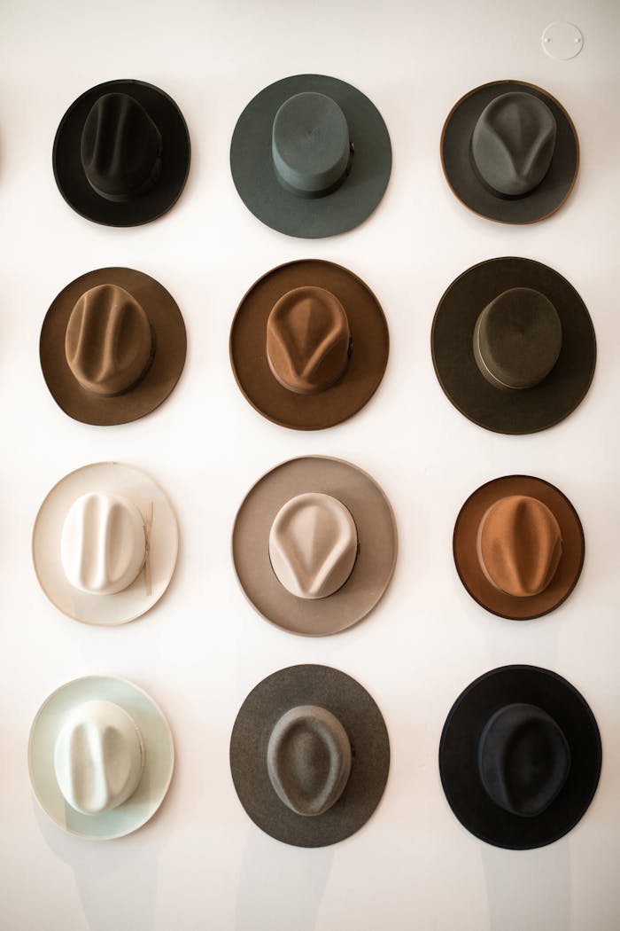 quality-assurance-02 A stylish collection of fedora hats arranged on a white wall, offering a glimpse into classic fashion.